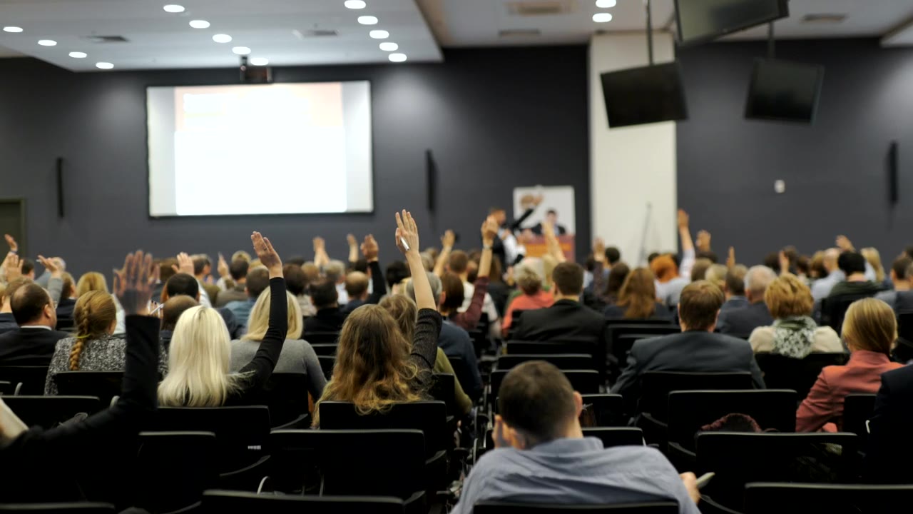 Conference audience facing a lit stage