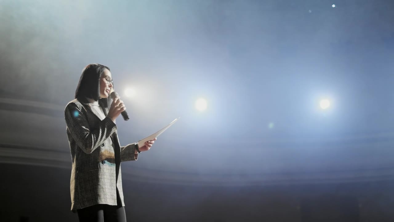 Speaker on stage under spotlights